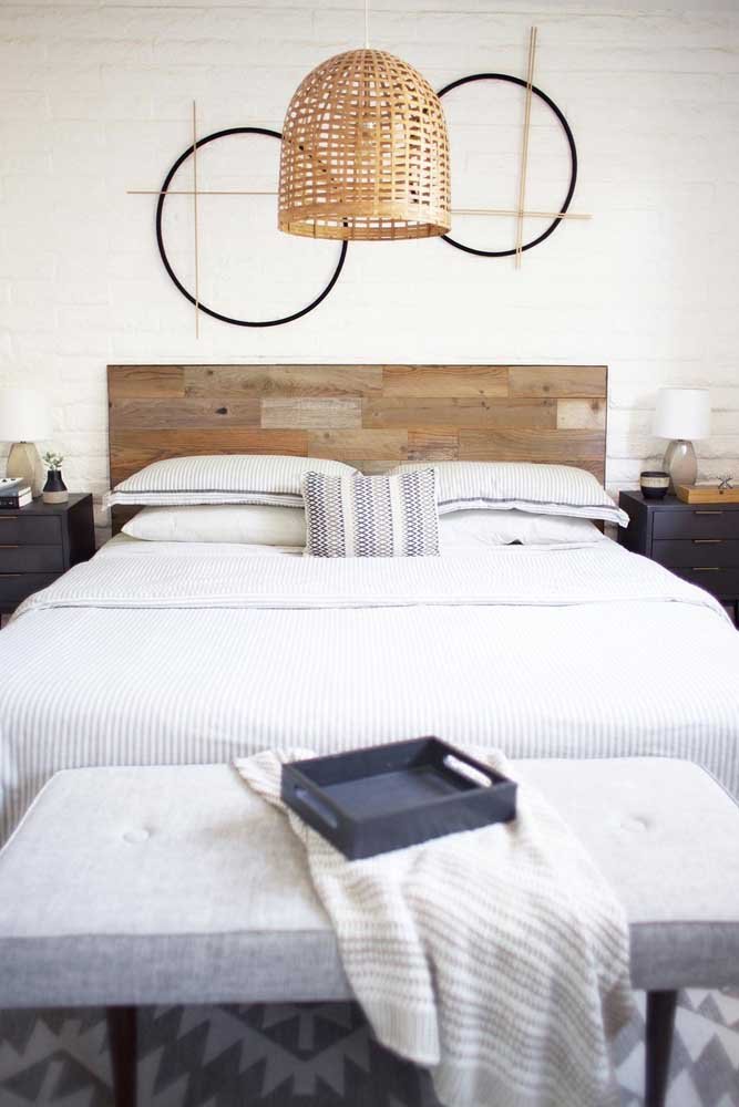 Os materiais naturais se destacam nesse quarto, incluindo os pallets usados para fazer a cabeceira