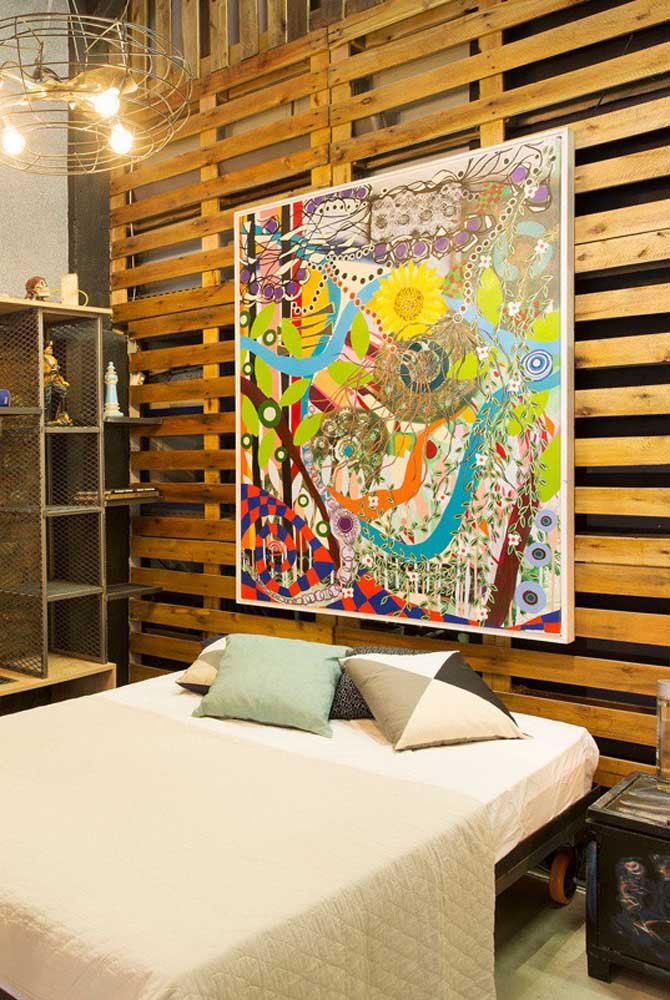 Aqui, o painel de pallet destaca o quadro colorido
