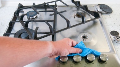 man cleaning a gas stove.
