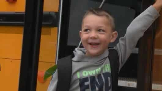 Photo of a school bus driver holding hands with a first grader too dread to separate from parents is going viral -