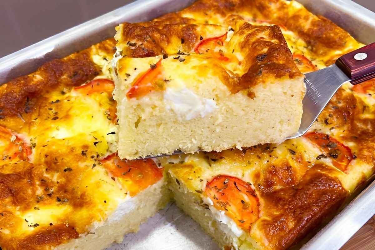 Torta salgada para o lanche com cobertura de queijo requeijão e tomates